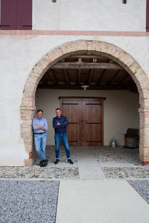 Foto von Mirco Pozzobon und eines Mitarbeiters unter einem Torbogen des Weinguts Case Paolin