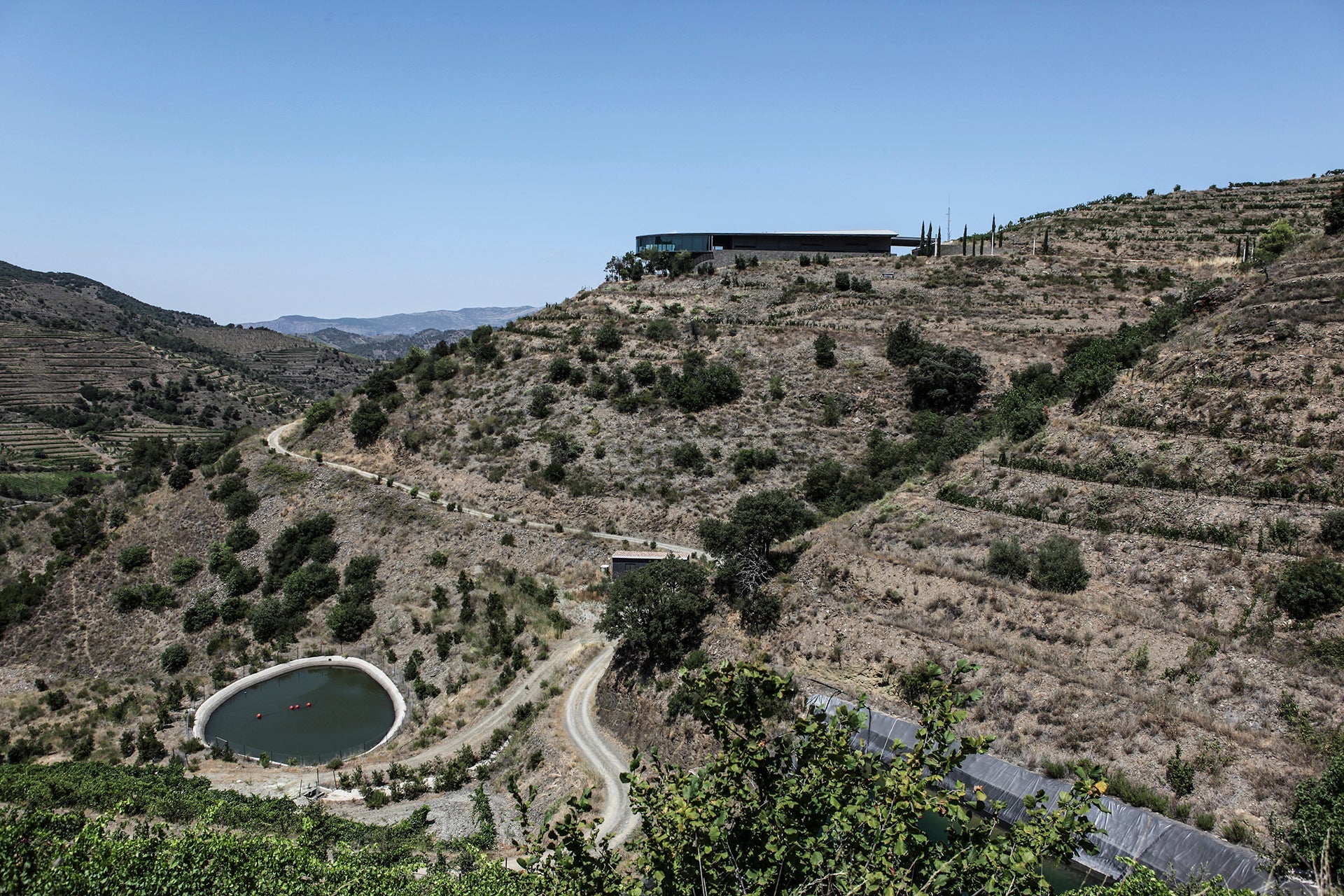 Futuristisches Kellereigebäude eingebettet in die Terrassenlagen der katalonischen Kellerei Ferrer Bobet im Priorat