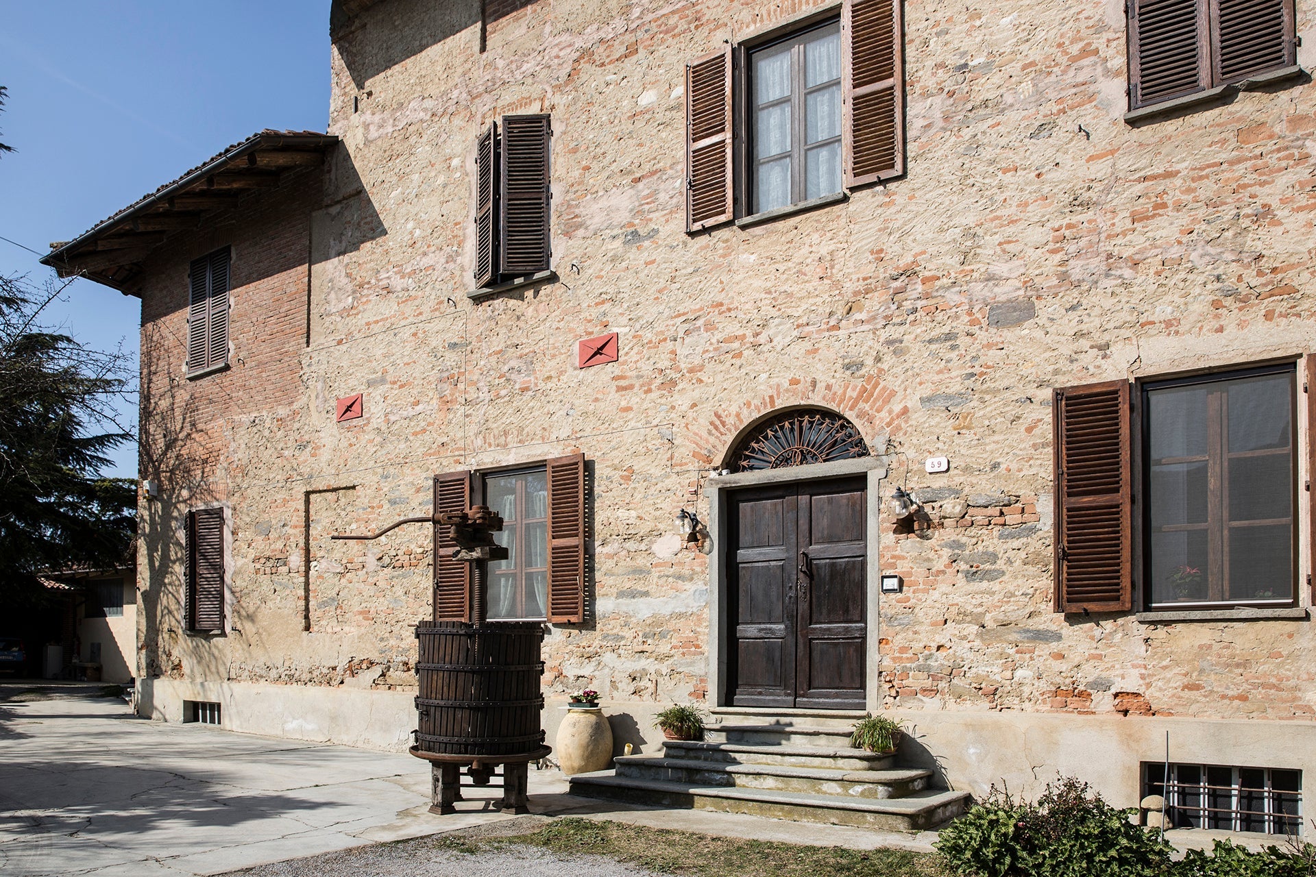 Historisches Stammhaus des Weinguts Fratelli Alessandria in Verduno im nördlichen Piemont mit antiker Korbpresse und Holztür