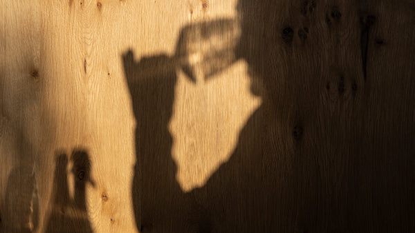 Foto des Schattens einer Person beim Verkosten von Wein